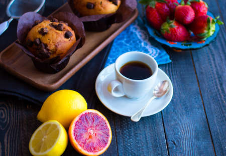 Breakfast with coffee and tea with different pastries and fruits on a wooden table free space for textの写真素材