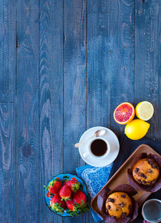 Breakfast with coffee and tea with different pastries and fruits on a wooden table free space for textの写真素材