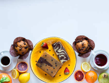 Breakfast with coffee and tea with different pastries and fruits on  a white wooden table free space for textの写真素材