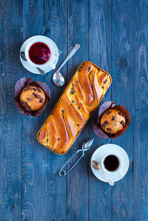 Breakfast with coffee and tea with different pastries and fruits on a wooden table free space for textの写真素材