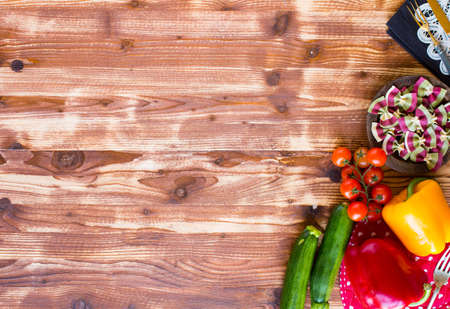 Italian pasta farfalle in tomato sauce and various type of vegetables on a wooden background, free space for text. Top viewの写真素材