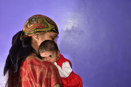 A mother with a child in her arms on a purple background.の写真素材
