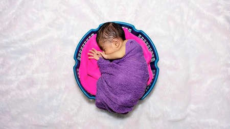 adorable smiling newborn baby. Newborn child relaxing in bedの写真素材