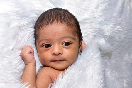 adorable smiling newborn baby. Newborn child relaxing in bedの写真素材