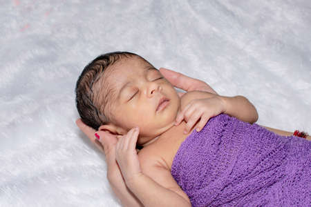 adorable smiling newborn baby. Newborn child relaxing in bedの写真素材