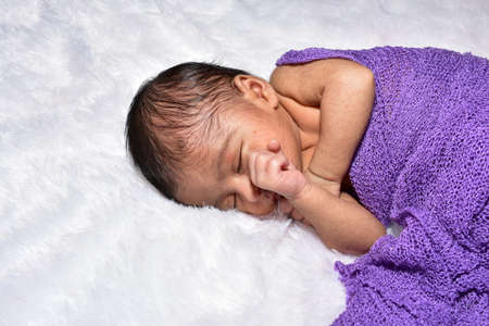 adorable smiling newborn baby. Newborn child relaxing in bedの写真素材
