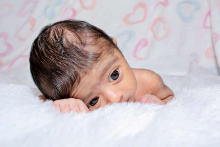 adorable smiling newborn baby. Newborn child relaxing in bedの写真素材