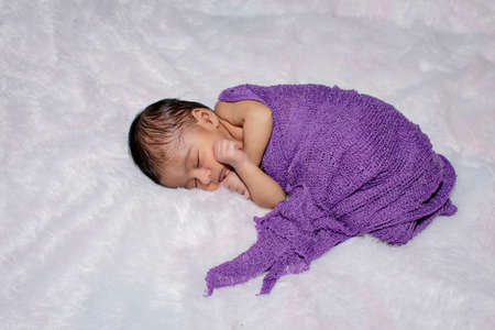 adorable smiling newborn baby. Newborn child relaxing in bedの写真素材