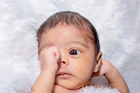 adorable smiling newborn baby. Newborn child relaxing in bedの写真素材