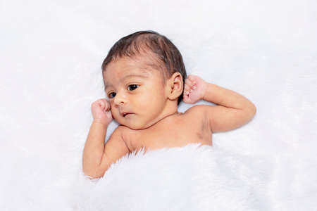 adorable smiling newborn baby. Newborn child relaxing in bedの写真素材