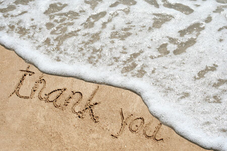 Conceptual thank you text in sand and water wave backgroundの写真素材