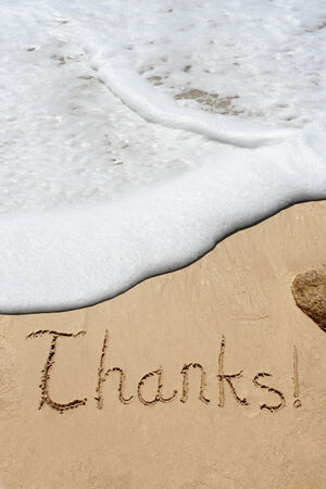 Conceptual thank you text in sand and water wave backgroundの写真素材