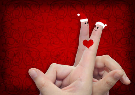 Conceptual Christmas fingers in love on vintage old red backgroundの写真素材