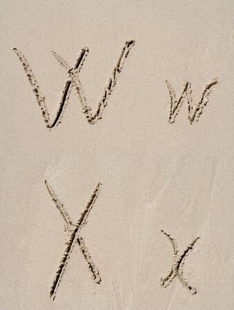 Sand font or letter set or collection carved on an exotic beach near the sea in summerの写真素材