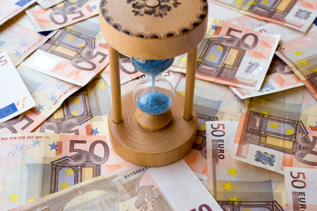 Concept or conceptual euro paper money banknote with a sand glass or time background