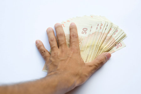 Concept or conceptual euro paper money banknote in human or man hands isolated on white background