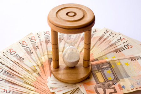 Concept or conceptual euro paper money banknote with a sand glass or time background