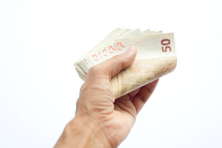 Concept or conceptual euro paper money banknote in human or man hands isolated on white background