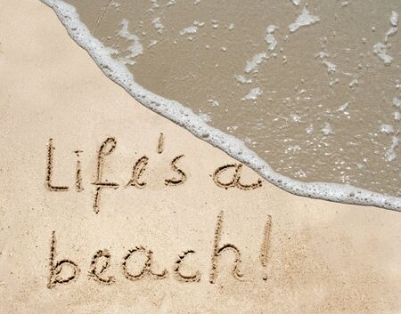 Conceptual life is a beach text in sand and water wave backgroundの写真素材