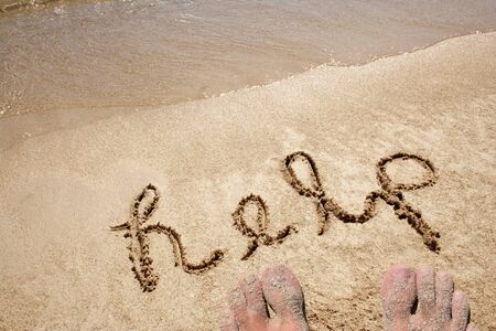 Help handwritten in sand for natural, symbol,tourism or conceptual designsの写真素材