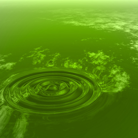 Conceptual green liquid drop falling in water with ripples and waves backgroundの写真素材