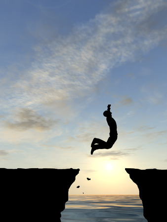 Conceptual business man silhouette jumping at sunset sky backgroundの写真素材