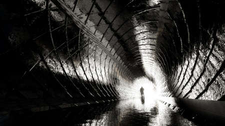 Concept or conceptual dark tunnel with a bright light at the end or exit as metaphor to success, faith, future or hope, a black silhouette of walking man to new opportunity or freedom 3d illustrationの写真素材