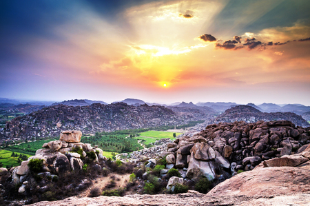 View to rice plantation from top of Hanuman monkey temple on hill at sunset in Hampi, Karnataka, India. Hampi sunset from hill.の写真素材