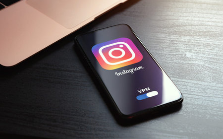 MOSCOW, RUSSIA - MAY 03, 2022: iphone lying on a wooden table, on the screen Instagram social...