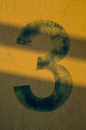the number 3 on the wall under the shadow of the lightsの写真素材