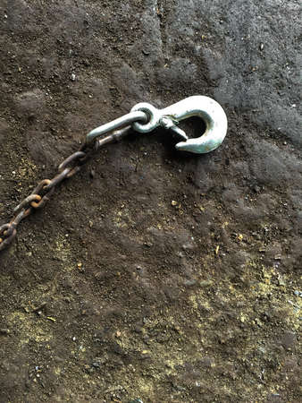 Old steel hook on dirty old cement floorの写真素材