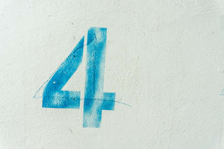 the number 4 on the dirty white wallの写真素材