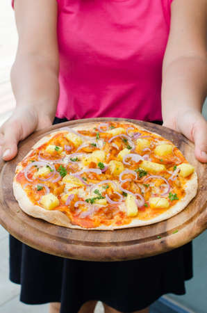 Holding a Hawaiian Chicken BBQ Italian Pizzaの写真素材