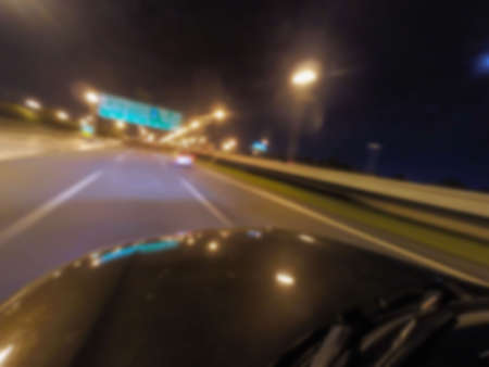 Abstract blurred . Speed driving car in the night on the highway roadの写真素材