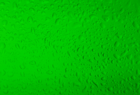 Texture water drops on the green bottle close-up as a background.の写真素材