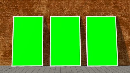 three green screen frames in front of brick wall on wooden floorの写真素材