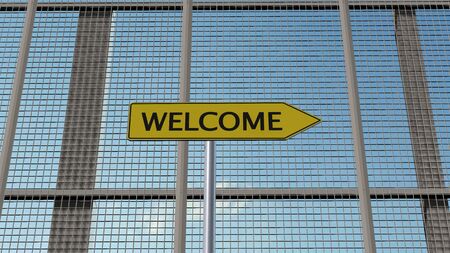 Welcome signpost on metal fence border fenceの写真素材