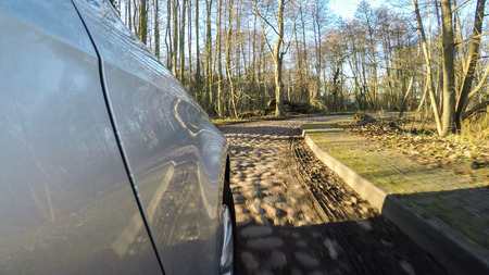 car driving on a old country road with blue skyの写真素材