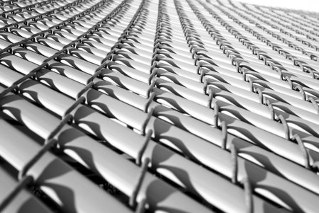 extreme view of a gray fence with shadow on plastic strips