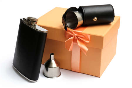 small leather hip flask with metal mug in cover at orange giftbox on a white backgroundの写真素材