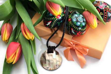 Composition of orange yellow tulips, painted Easter eggs and gift boxの写真素材