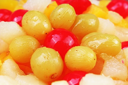 Fruit salad texture. Fruits as background pattern. Exotic Fruits Fruit salad with cocktail cherry sour cherry mango pineapple grapes,pear,papaya in syrup.の写真素材