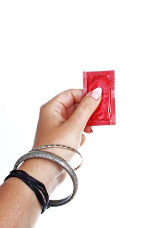 Woman hand holding condom on isolated white cutout background. Studio photo with studio lighting easy to use for every concept.の写真素材