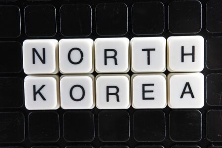 North Korea white text word on black cover. Text word crossword. Alphabet letter blocks game texture background.の写真素材