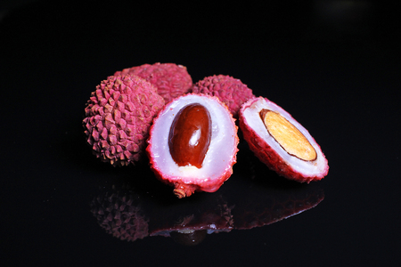 Litchi chinensis. Exotix litchi fruit fruits on black reflective studio background. Isolated black shiny mirror mirrored background for every concept. Litchi.の写真素材