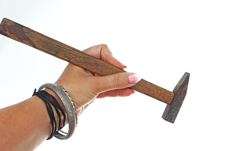 Woman hand holding hammer on isolated white cutout background. Studio photo with studio lighting easy to use for every concept..の写真素材