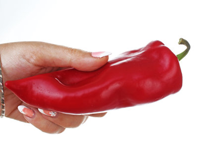 Woman hand holding red pepper paprika on isolated white cutout background. Studio photo with studio...