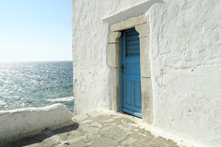 Mykonos, Greece  A blue door on a whitewashed wall. The entrance to one of the five churches that form The Church of Panagia Paraportiani.の写真素材