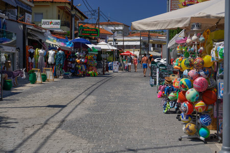 Souvenirs and food shops at the narrow streets of Hanioti seaside town at Chalkidiki peninsula, Greece  on a hot summer day.のeditorial素材