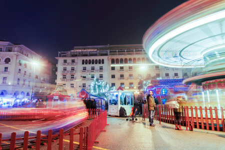 Thessaloniki, Greece Christmas 2018 decorations at Aristotelous square. Night view of festive installments at main square with vintage fairground carousel rotating in blurred motion.のeditorial素材
